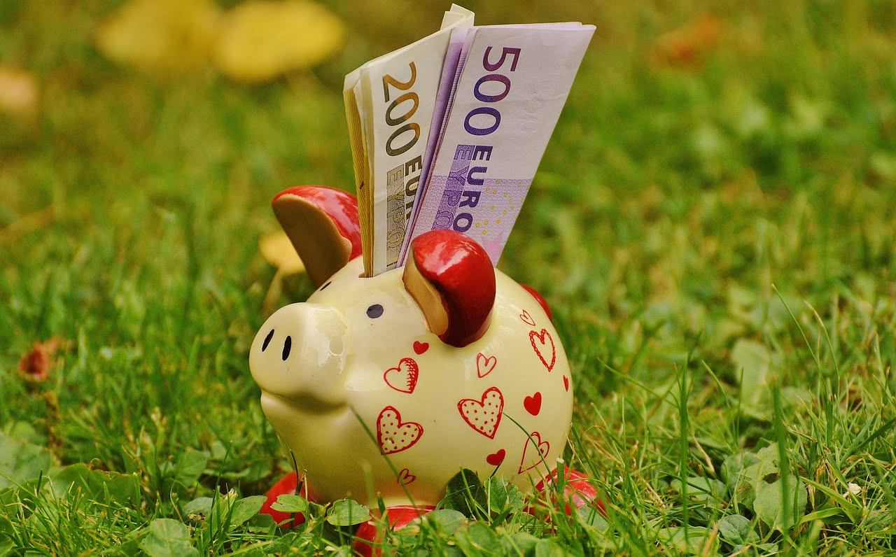 Persona che gestisce il budget finanziario personale con grafico di risparmio e fondo emergenza su tavolo di lavoro