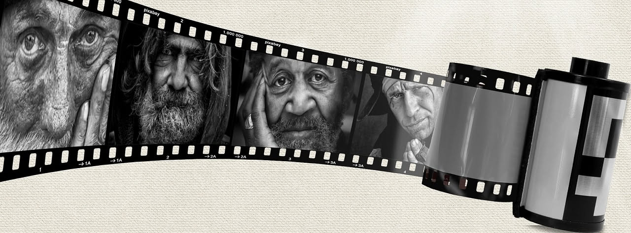 Sala cinematografica buia con luce dello schermo che illumina il pubblico emozionato durante la proiezione di un film