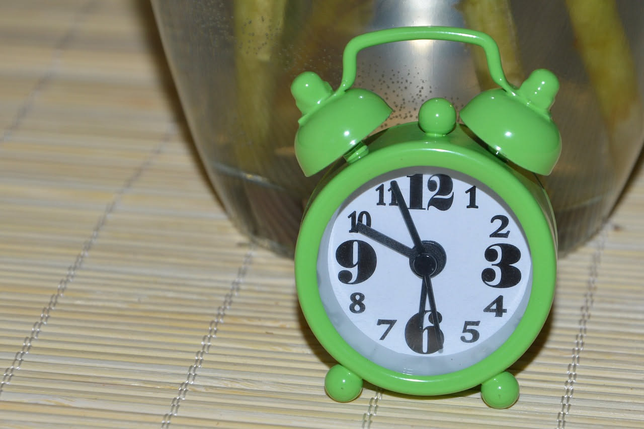 Persona stanca al risveglio guarda lo smartphone a letto di notte con luce blu dello schermo in camera buia