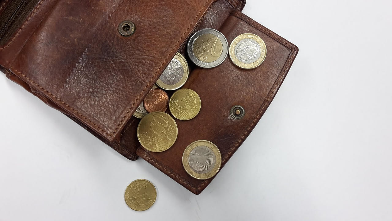 Illustrazione di una persona in confusione davanti a grafici finanziari e simboli di denaro, che rappresenta i bias cognitivi nelle decisioni economiche
