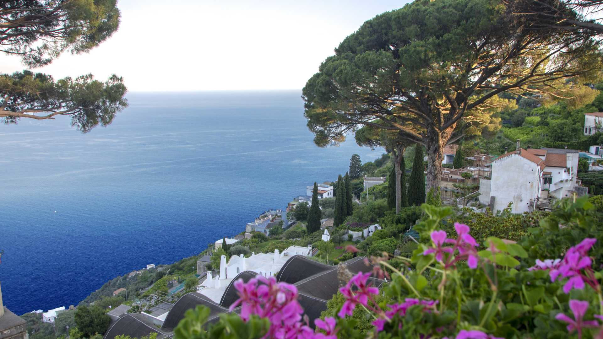 Veduta del giardino di Villa San Michele ad Anacapri con piante grasse, palme nane e fiori colorati disposti su terrazzamenti rocciosi affacciati sul mare
