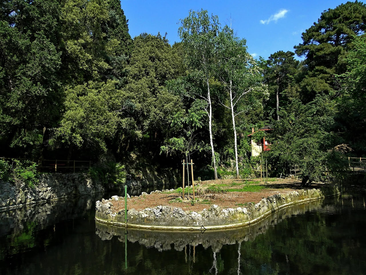 Archi in travertino dell'Acquedotto Claudio ricoperti di edera e muschio, circondati da pini domestici, querce e vegetazione spontanea verde in una giornata di sole a Roma