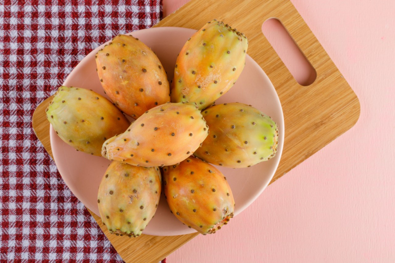 Fichi d'India maturi tagliati a metà su un piatto, con la polpa colorata arancione e rossa ricca di semi, frutto tipico di agosto