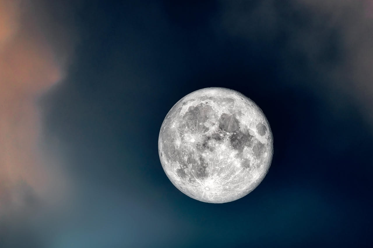 Antica tavoletta con simboli astronomici accanto a spighe di grano sotto una grande luna piena, in un paesaggio agricolo al crepuscolo