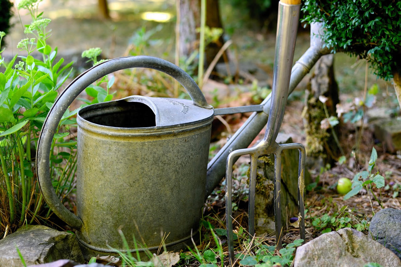 Persona anziana sorridente che cura le piante in vaso su un balcone al sole, immagine dei benefici per corpo e mente di chi fa giardinaggio